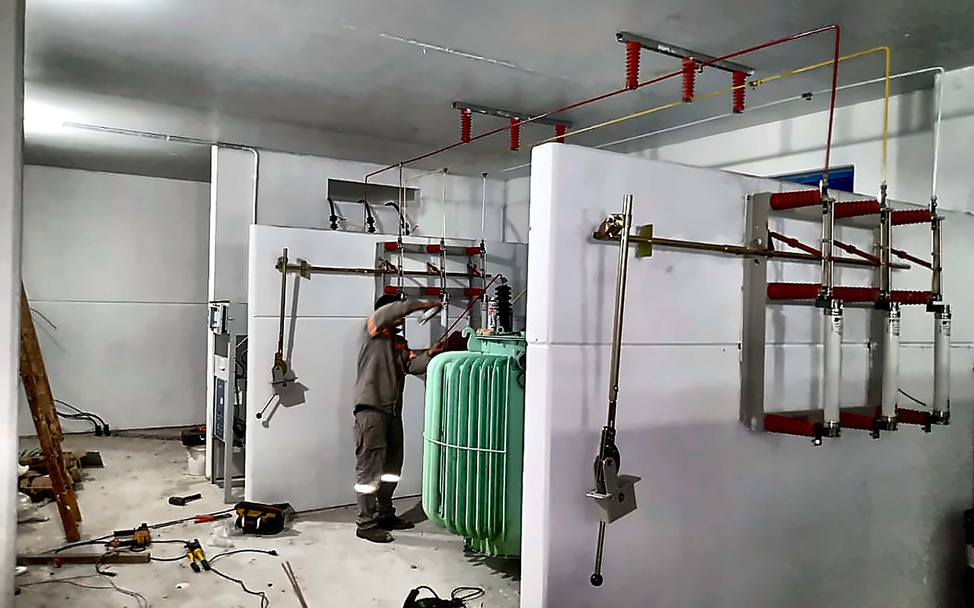 Vista interna da subestação abrigada CORSAN Imbé com transformador de 500kVA e operário da Sete Engenharia