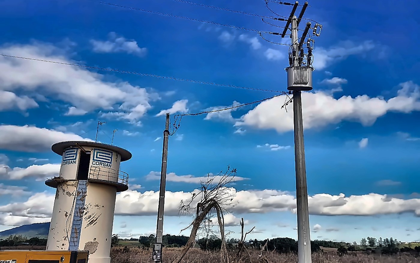 Reservatório CORSAN com logo visível e poste novo com transformador instalado pela Sete Engenharia durante operação emergencial das enchentes de 2024 no Vale do Taquari